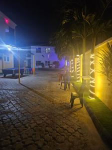 a park with benches and palm trees at night at The Maison Lodge in Ijegun
