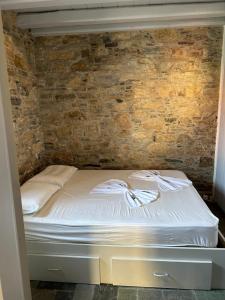 a bed in a room with a brick wall at Samos Vista Azzurra 1 in Samos +27 photos