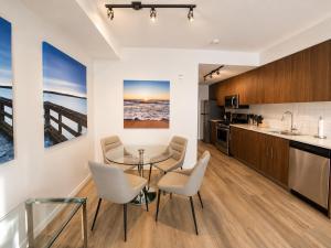 a kitchen and dining room with a table and chairs at Perfect Brand New Condo Downtown Sidney in Sidney