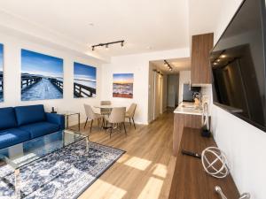 a living room with a blue couch and a table at Perfect Brand New Condo Downtown Sidney in Sidney