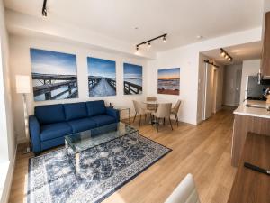 a living room with a blue couch and a table at Perfect Brand New Condo Downtown Sidney in Sidney
