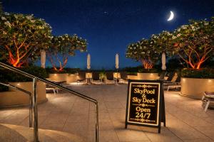 a sign for a restaurant at night with trees at Pacific Club Resort in Karon Beach +25 photos