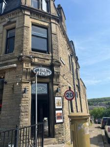 a brick building with a sign in front of it at Venue Apartment in Colne