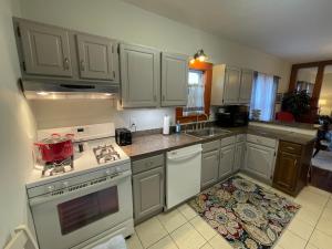a kitchen with white cabinets and a stove top oven at Inviting 3 Bedroom Home in Norton