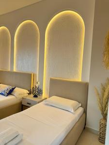 two beds in a room with arched ceilings at Hotel Imperial in Dhërmi