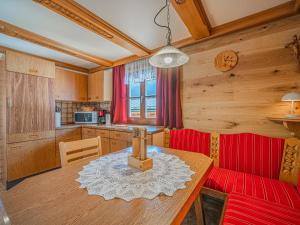 a kitchen with a wooden table and a red couch at Elisabeth II in Wald im Pinzgau +11 photos