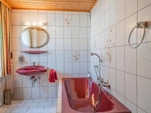 a bathroom with a red tub and a sink at Elisabeth II in Wald im Pinzgau