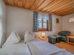 a bedroom with a bed and a chair and a window at Elisabeth II in Wald im Pinzgau