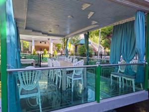 a balcony with white chairs and a table and a fence at Heaven resort hotel in ToÄŸanalÄ±