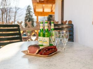 a table with bottles of wine and meat and wine glasses at Apartment Birgit in Zellberg