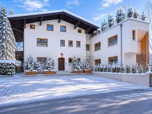a house in the snow with a driveway at Kitz Apartments Top 6 in Kitzbühel