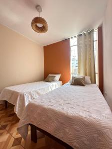 a bedroom with two beds and a window at Cozy house in San Pedro