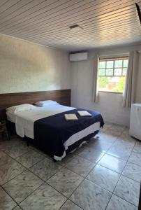 a bedroom with a bed with two towels on it at Pousada chafariz in Pirenópolis +5 photos