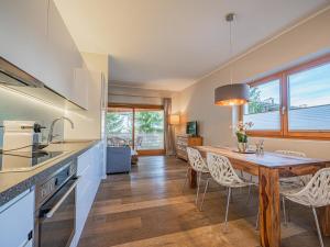 a kitchen and dining room with a wooden table and chairs at Kitz Apartments Top 7 in Kitzbühel +12 photos