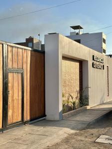 a building with a wooden gate and a garage at Cozy house in San Pedro
