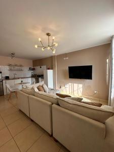 a living room with a row of couches and a television at Cozy house in San Pedro