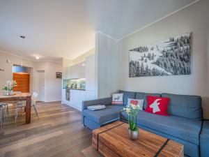 a living room with a blue couch and a table at Kitz Apartments Top 7 in Kitzbühel
