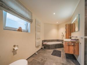a bathroom with a tub and a toilet and a window at AlpenHerz in Jochberg +14 photos