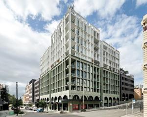 a large white building on a city street at Stylish CBD Apartment with Courtyard and Parking in Newcastle