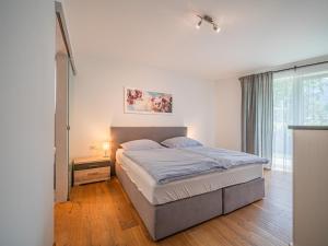 a bedroom with a large bed and a window at AlpenHerz in Jochberg