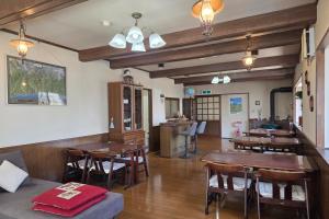 a dining room with wooden tables and chairs at Wolke Lodge in Shinano