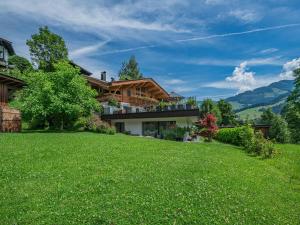 a house on a hill with a green lawn at AlpenHerz in Jochberg