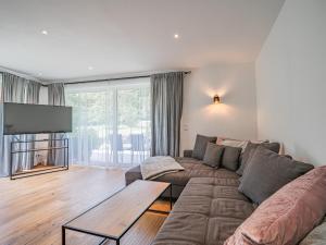 a living room with a couch and a flat screen tv at AlpenHerz in Jochberg