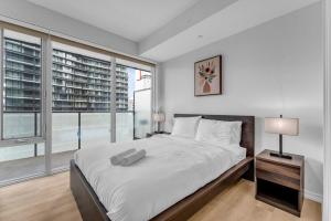 a bedroom with a large bed and a large window at Altitude Residences in Toronto