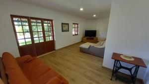 a living room with a couch and a television at Monte da Cardela Nova in Melides