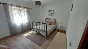 a bedroom with a crib in a room with a window at Monte da Cardela Nova in Melides +29 photos