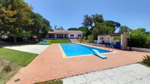 a swimming pool in front of a house at Monte da Cardela Nova in Melides