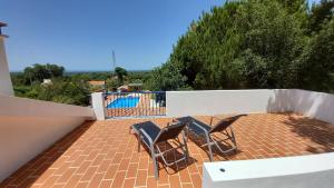 a balcony with two chairs and a swimming pool at Monte da Cardela Nova in Melides