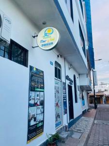 a white building with a sign on the side of it at Hostal Marysol in Puerto Ayora