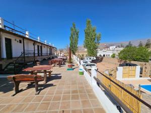 a row of benches on a sidewalk in a town at Los Toneles Cafayate in Cafayate