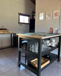 a table with glasses on it in a kitchen at Chalé Lumiar in Santana do Riacho