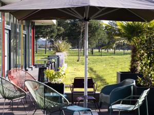 a group of chairs and an umbrella on a patio at ibis budget Gonesse Le Bourget in Gonesse