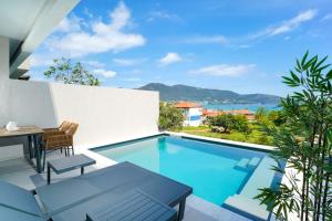 a swimming pool with a table and chairs and the ocean at Videre Golden Private Pool Suites in Potamiá