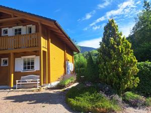 a yellow house with a bench in front of it at Le Temps-Passe in Saint-Jean-d'Aulps