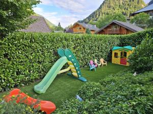 a playground with a slide in a garden at Le Temps-Passe in Saint-Jean-d'Aulps