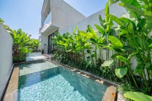 a swimming pool in front of a building with plants at U Villas - Tropical Views Luxury Stay with Pool & Workspace in Ungasan +127 photos