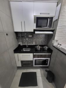 a small kitchen with a sink and a microwave at Recanto de Paz Lapa - RJ in Rio de Janeiro