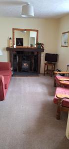 a living room with a fireplace and a red couch at Lee Cottage Appledore in Appledore