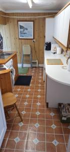 a kitchen with a tiled floor with a table and a chair at Lee Cottage Appledore in Appledore