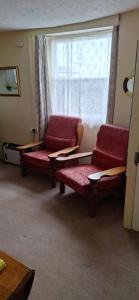 a living room with two chairs and a window at Lee Cottage Appledore in Appledore