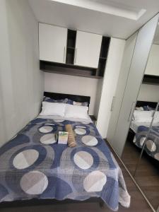 a bedroom with a bed with a blue and white blanket at Recanto de Paz Lapa - RJ in Rio de Janeiro
