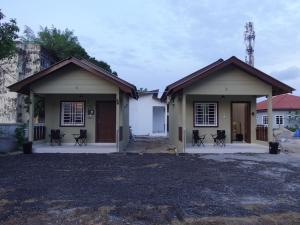 a couple of buildings with chairs in front of them at IA Tiny House 2 in Dungun