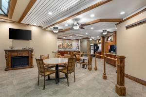 a dining room with a table and chairs and a fireplace at Best Western Plus Wooster Hotel & Conference Center in Wooster