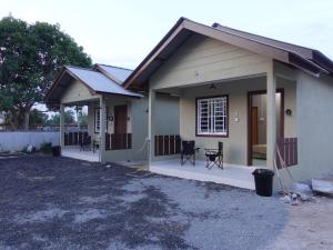 a small house with a porch and two chairs at IA Tiny House in Kampong Sura Tengah