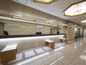 a lobby with a cashier counter and benches at Meitetsu Komaki Hotel in Komaki