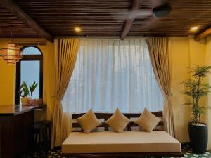 a room with a couch in front of a window at Staypineapple in Quy Nhon